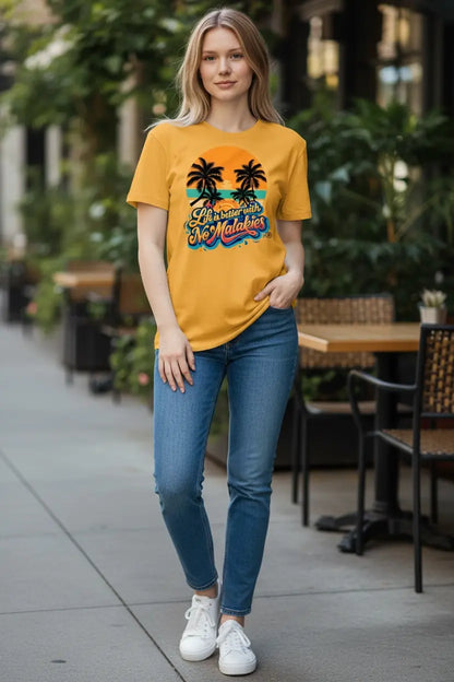 Woman wearing a yellow t-shirt with palm tree design in an outdoor setting